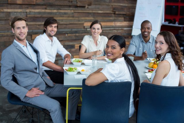 Smiling business executives having meal in office