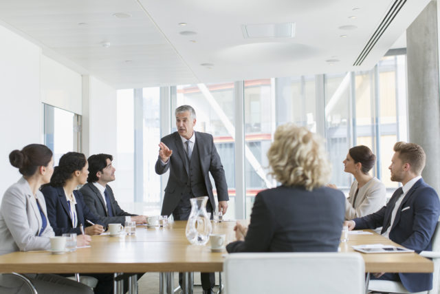 Corporate businessman leading conference room meeting
